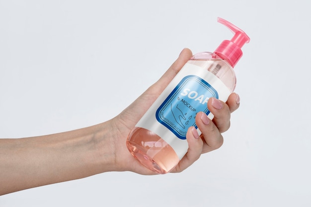 Hand holding bottle of liquid soap