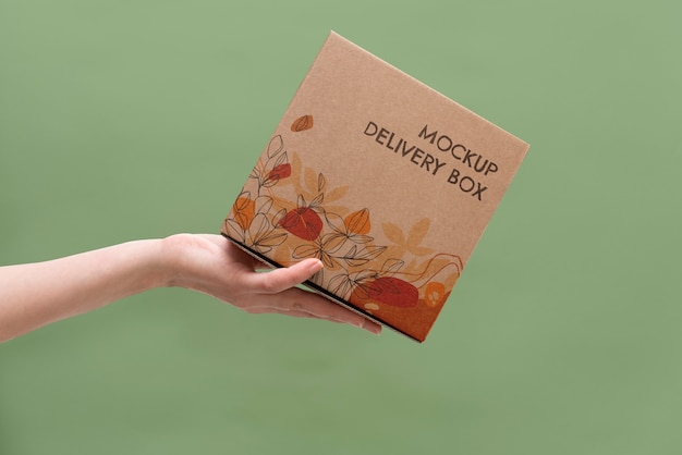 Hand holding box mockup