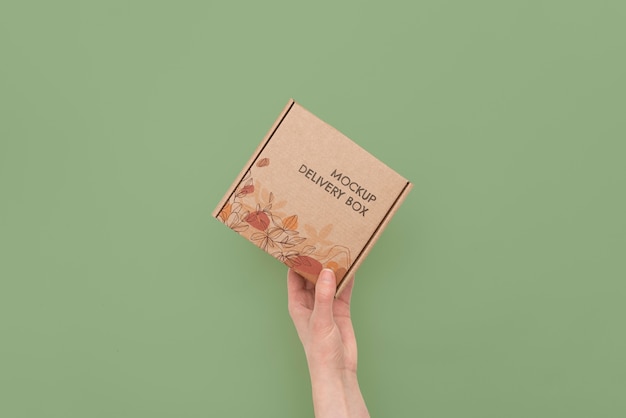 Hand holding box mockup