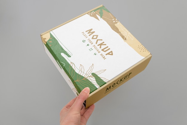 Hand holding box mockup