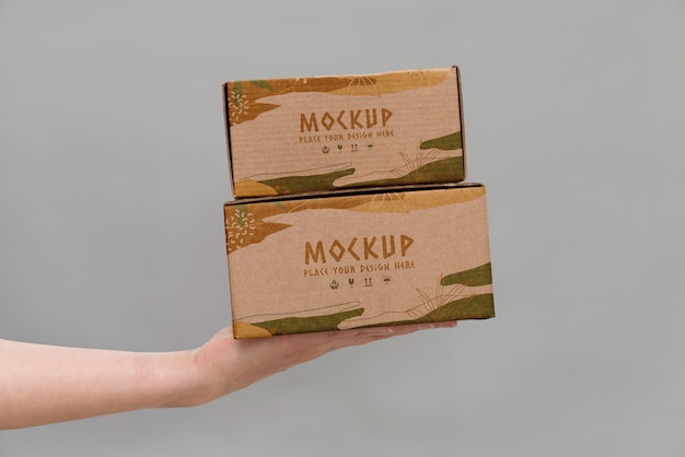 Hand holding boxes mockup