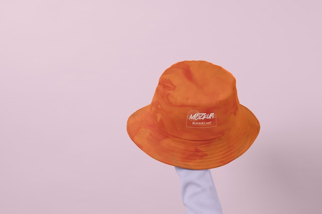 Hand holding bucket hat in studio