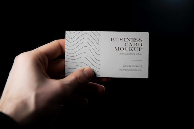 Hand holding a business card mockup