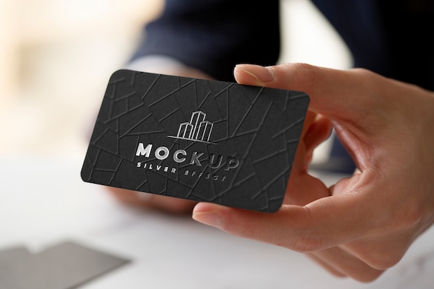 Hand holding business card with silver logo