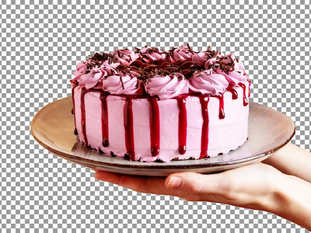 透明な背景にピンクのアイシングとチョコレートの赤い滴りのケーキを持っている手