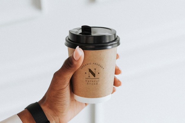 Hand holding a coffee cup mockup