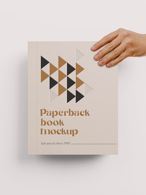 Hand holding paperback book mockup