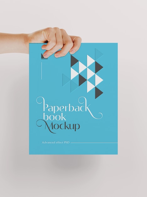 Hand holding paperback book mockup
