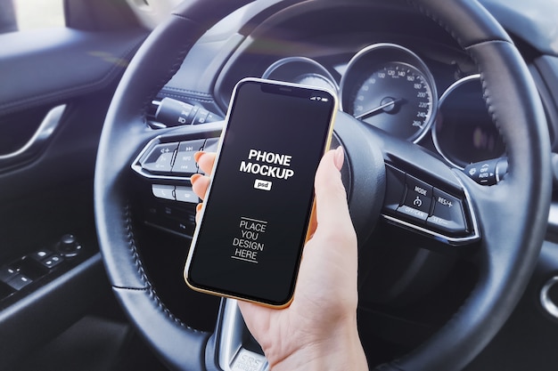 PSD hand holding phone in car salon mockup