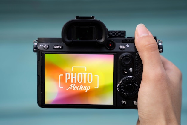 Hand holding photo camera with blue background