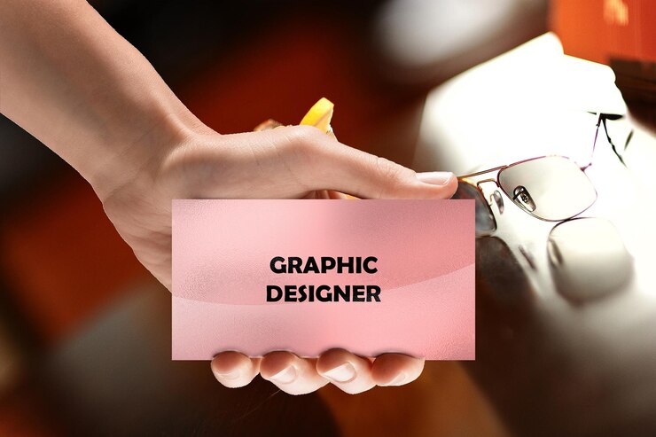 PSD a hand holding a pink card that says graphic designer mockup psd