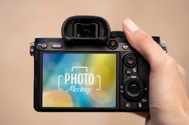 Hand holding professional photo camera mockup