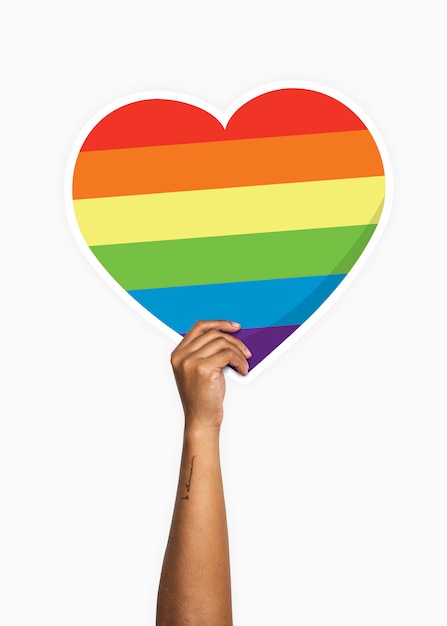 Hand holding a rainbow heart cardboard prop