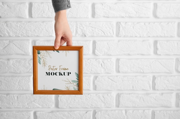 PSD hand holding simple wooden frame mockup