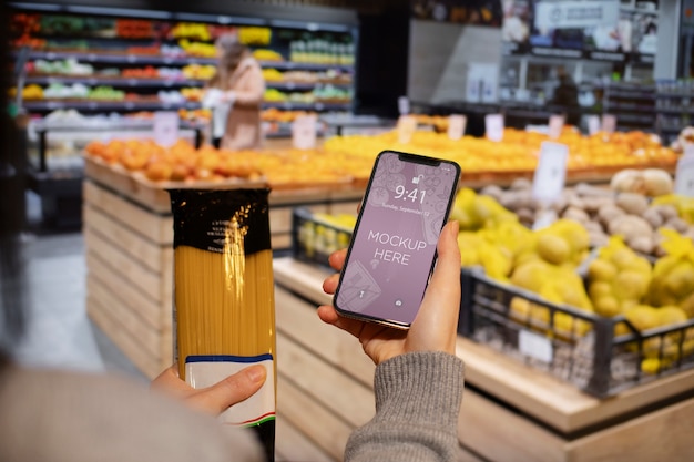 PSD hand holding smartphone in supermarket