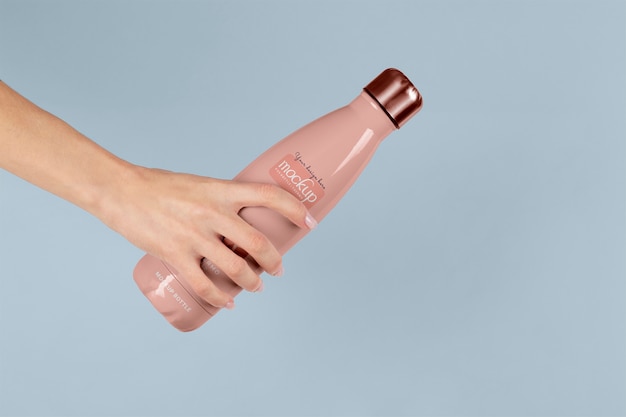 Hand holding thermos mockup