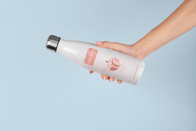 Hand holding thermos mockup