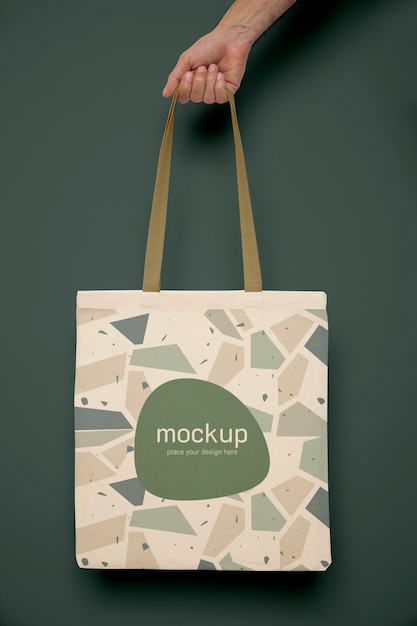 PSD hand holding tote bag with green background