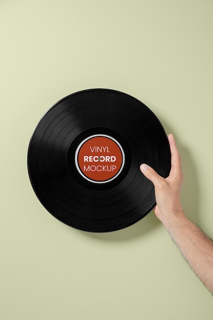 PSD hand holding vinyl record with green background