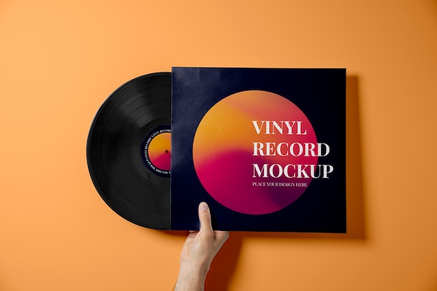 PSD mano che tiene il disco in vinile con sfondo arancione