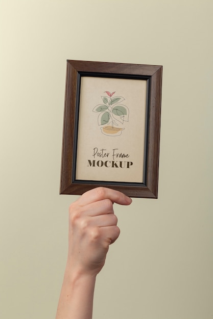 Hand holding wooden frame mockup