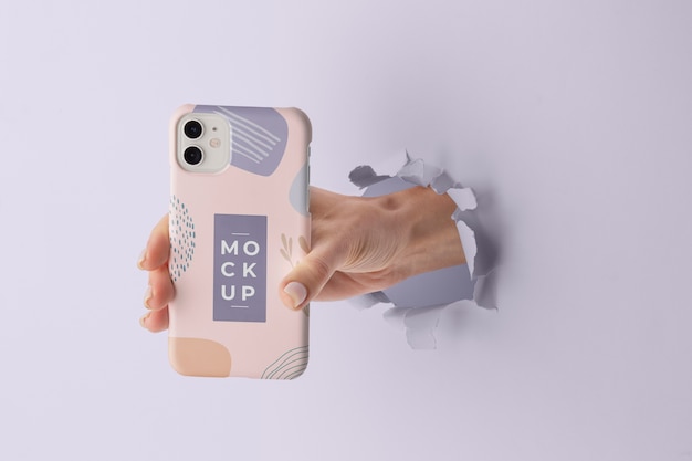 PSD hand met smartphone met mock-up telefoonhoesje door muurscheur