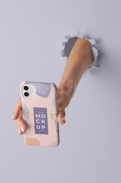 PSD hand met smartphone met mock-up telefoonhoesje door muurscheur