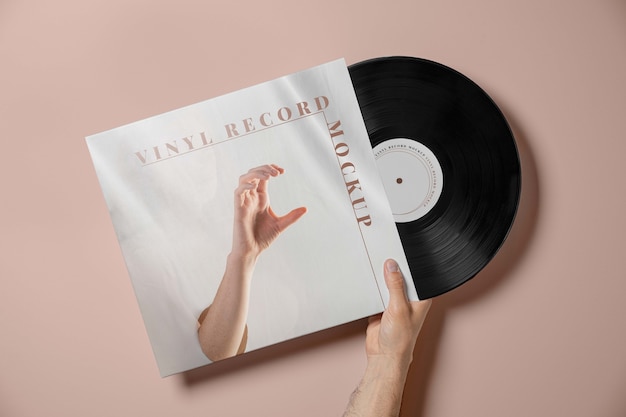Hand met vinylplaat en roze achtergrond