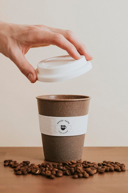 Hand openen van een herbruikbare koffiekop mockup