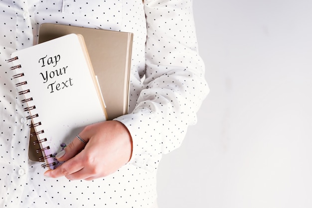 Hand of a woman holds in hands a notebook, business concept mock up