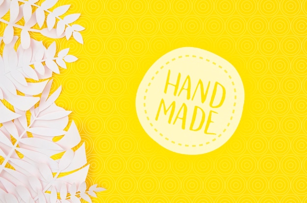 PSD handmade badge with white leaves on yellow background