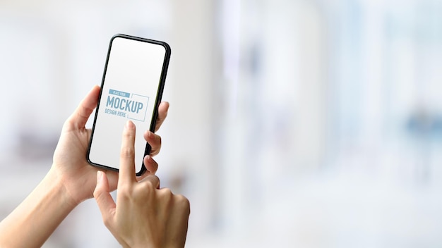 手がモックアップのスマートフォンに触れている