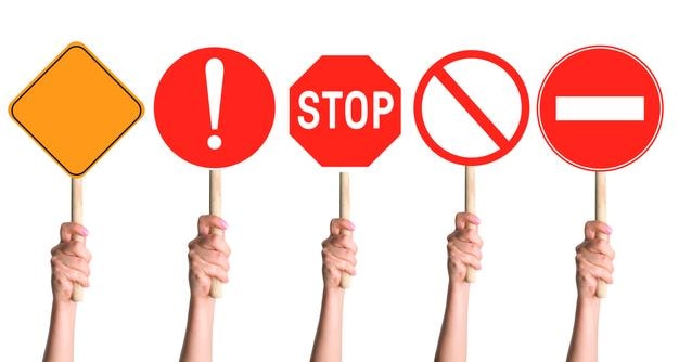 PSD hands holding a set of prohibition signs on a stick on a blank background