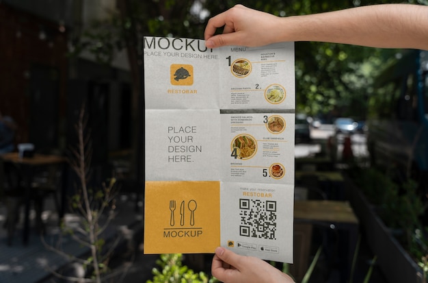 PSD hands holding folded restobar brochure mock-up