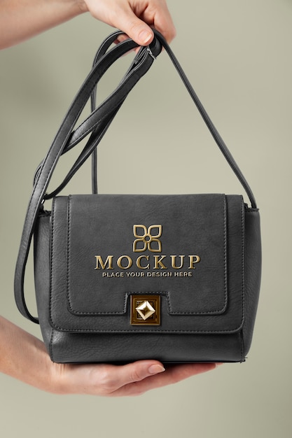 PSD hands holding grey handbag with golden logo