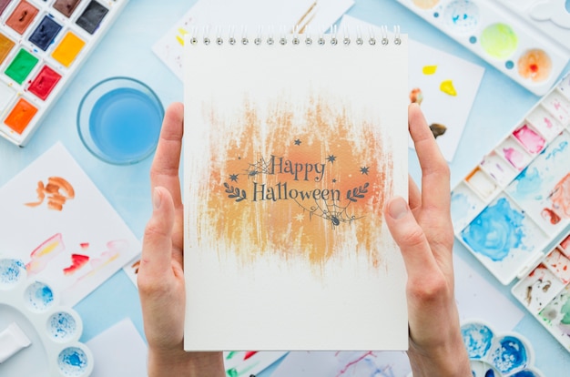 PSD hands holding notebook with halloween message