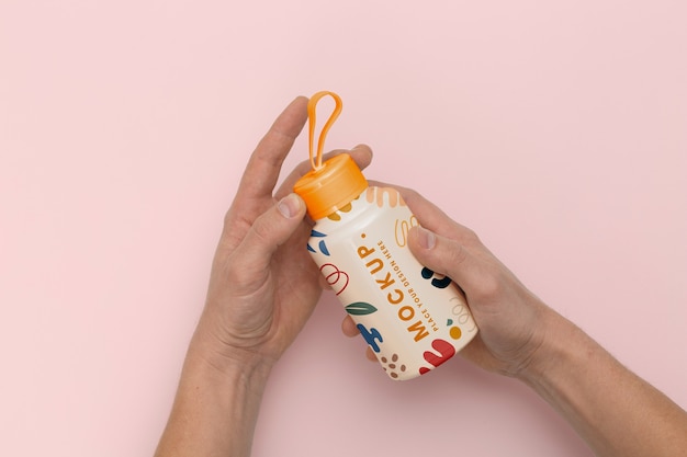 Hands holding reusable bottle flat lay