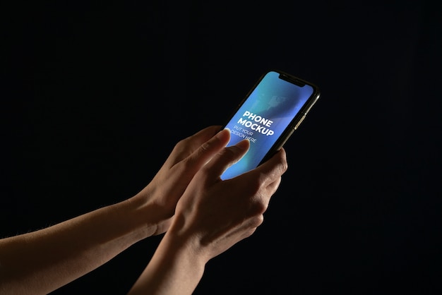 PSD Руки держат макет смартфона на цветном фоне