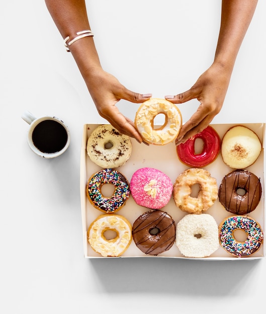 Hands holding sweeten donut dessert in aerial view