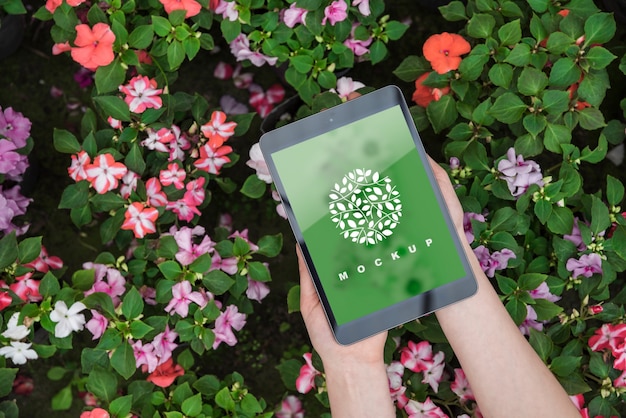 Hands holding tablet mockup with gardening concept