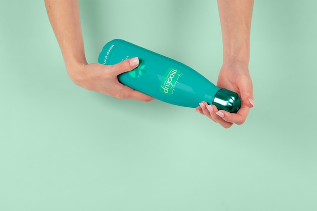 Hands holding thermos mockup