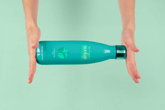 Hands holding thermos mockup