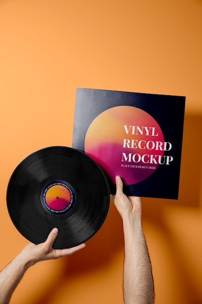 PSD mani che tengono il disco in vinile con sfondo arancione