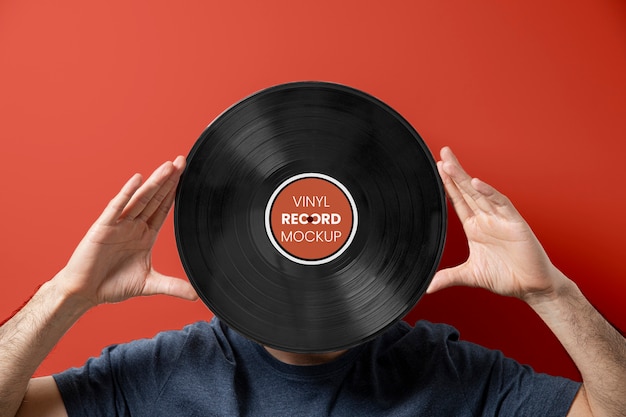 PSD hands holding vinyl record with red background