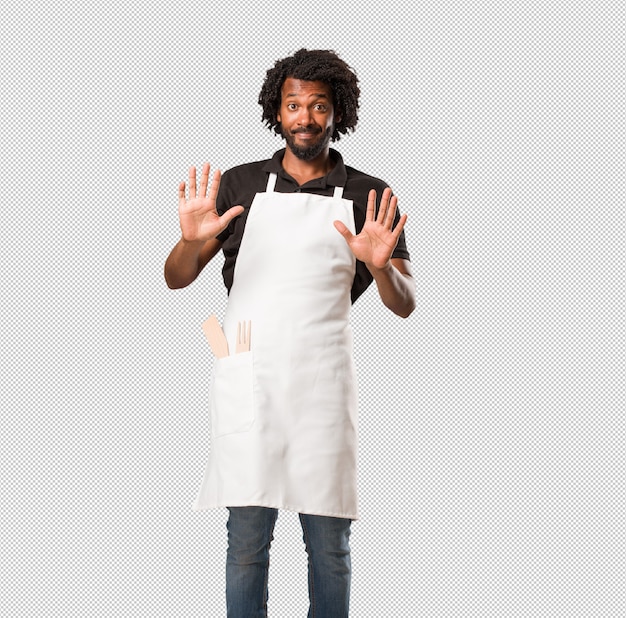 PSD handsome african american baker serious and determined, putting hand in front, stop gesture, deny concept