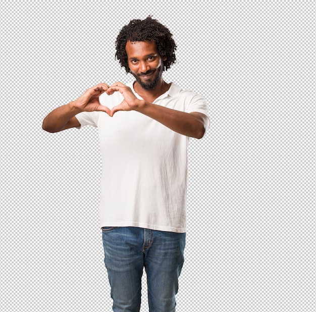 Handsome african american making a heart with hands, expressing the  love and friendship, happy and smiling