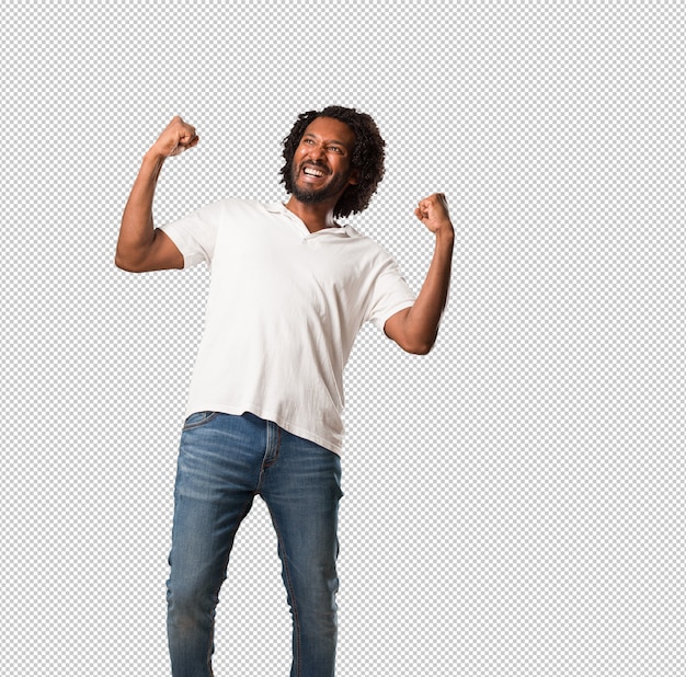 Handsome african american very happy and excited, raising arms, celebrating a victory or success, winning the lottery