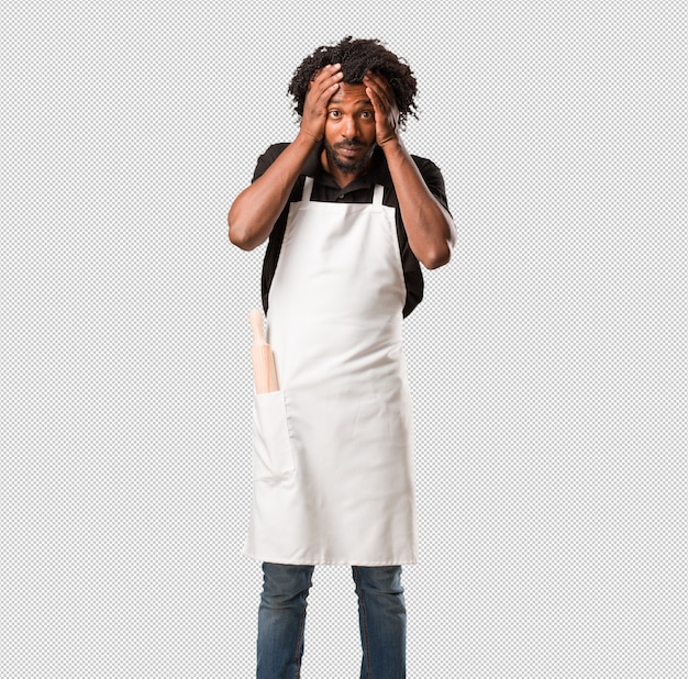 Handsome black man baker frustrated and desperate, angry and sad with hands on head