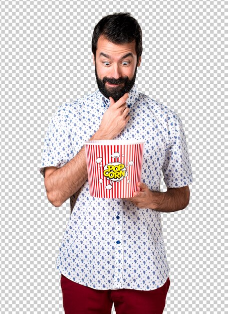 PSD handsome brunette man with beard eating popcorns