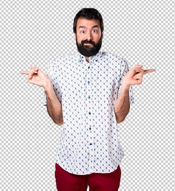 PSD handsome brunette man with beard pointing to the laterals having doubts